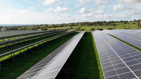A drone image of solar panels on green fields in Jersey.