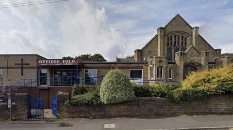 Street view of Revidge Fold United Reformed Church. To the right is a traditional looking stone entrance and to the left is a flat roofed, single storey annex