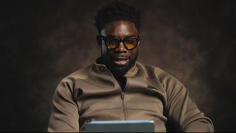 Micah Richards watching something on a tablet device
