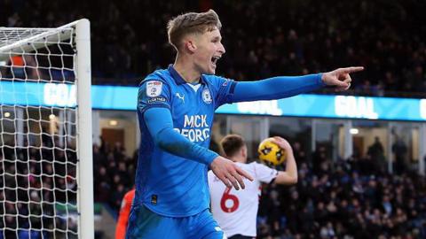 Jimmy-Jay Morgan points at his team-mate after scoring a goal for Peterborough