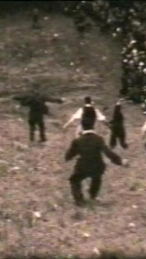 Black and white image of men in suits running down hill