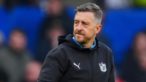 Jon Brady looks to his left as he walks off the field for half-time