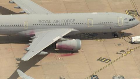 The RAF plane at Brize Norton, with red paint sprayed on it. 