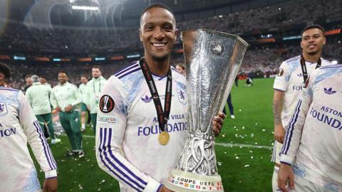 Ezri Konsa holding Uefa Europa League trophy