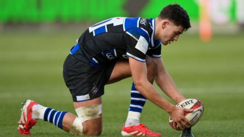 Orlando Bailey of Bath Rugby lines the ball up for a kick