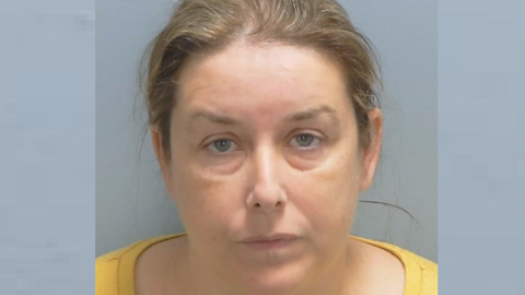 A custody photo shows Shelley Simpson with tied-back, light brown hair and wearing a yellow top.
