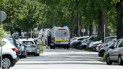 Ambulance cars are seen in a street close to a school where, according to reports, several people died in a shooting