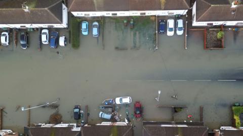 An aerial photograph of houses and homes surrounded by flood water