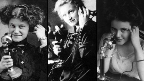 Three Victorian women using telephones of the day. They are holding a separate mouthpiece and earpiece