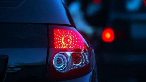 A close-up of a car's rear headlight at night.