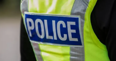 Police officer wearing a high vis jacket that says "police"