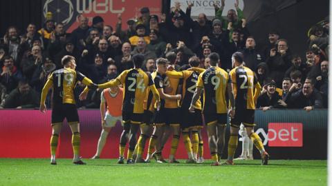 Newport County players celebrate taking the lead.