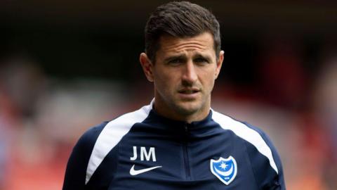 Portsmouth manager John Mousinho wearing a club tracksuit