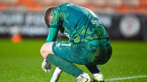 Yevhen Kuchurenko crouches on his haunches