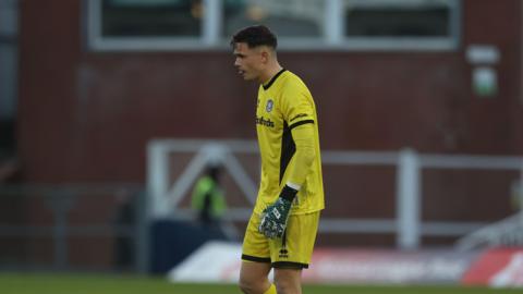 A photo of Jed Ward, wearing his yellow goalkeeping kit, playing for Yeovil Town during their match against Hartlepool in December