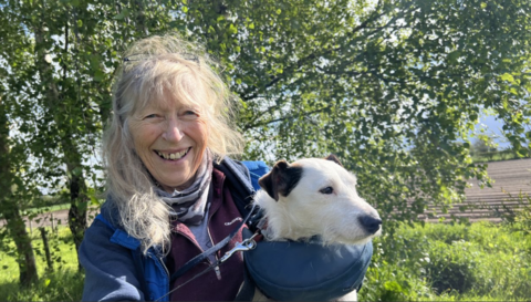 Glynis Elgey pictured with Krakka. She has long fair hair and is wearing a blue jacket. She is holding Krakka in her arms and smiling.