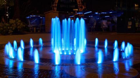 A fountain lit up in sky blue lighting