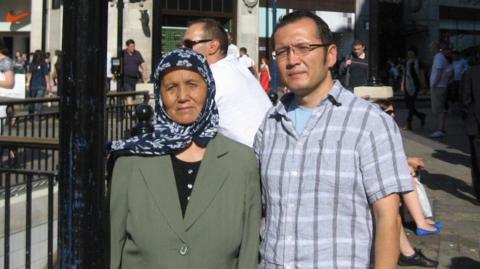 Aziz and his mother Helizkhan stood in front of Oxford Circus Station in London in the sunshine