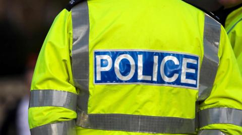 A picture of the back of a police officer's high-vis jacket.