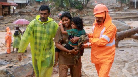 Rescuers help residents to move to a safer place, at a landslide site after multiple landslides in the hills, in Wayanad, in the southern state of Kerala, India, July 30, 2024.