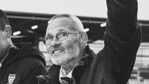 Alan Little at a football game, in black and white