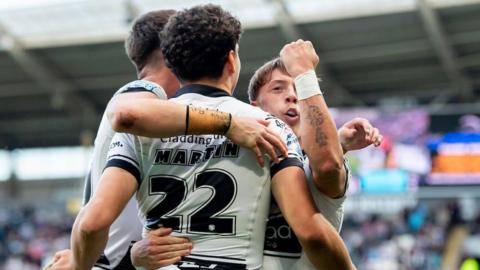 Hull FC player Lewis Martin is congratulated by teammates after scoring against Warrington Wolves.