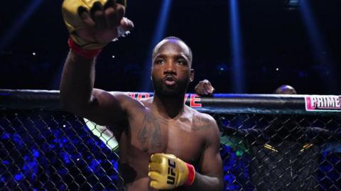 Leon Edwards aims a shadow punch at the camera as he waits for a fight to start