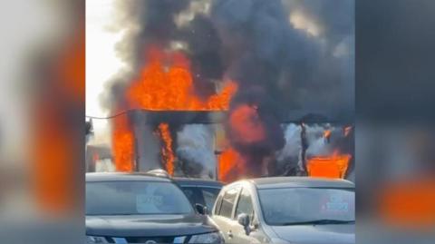 Commercial unit alight behind a row of cars, in Bognor Regis, West Sussex