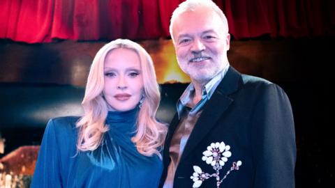 Madonna and Graham Norton stand side-by-side.