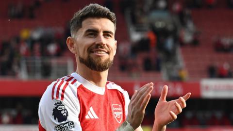 Jorginho wearing an Arsenal shirt applauding fans