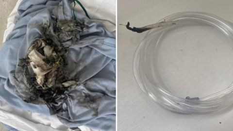 A composite image of the fire damage. On the left, a blue and white hospital blanket is scorched black in the middle. On the right, a coiled oxygen tube is singed black at the end. A plastic section, that has fallen off the tube, is burnt too.