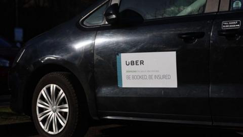 A Uber logo is displayed on a Uber taxi car