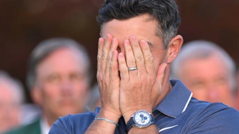 Rory McIlroy covers his face with his hands