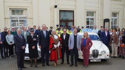 Dignitaries stood in front of vintage police cars outside the Old Police Cells Museum, in Brighton