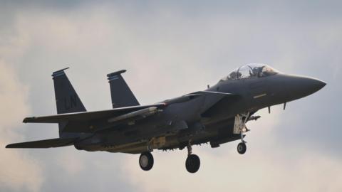 A F-15E plane flying in the sky.