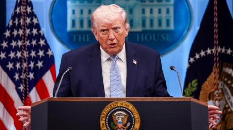 Donald Trump speaks from a podium.