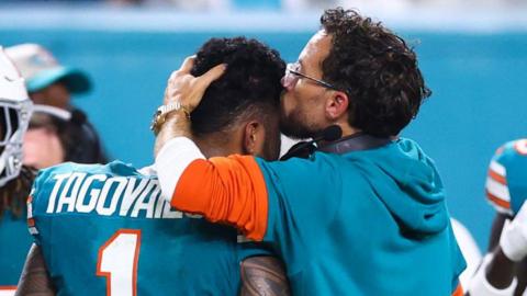 Miami Dolphins coach Mike McDaniel kisses quarterback Tua Tagovailoa on the head as he leaves the field after suffering a concussion in September 2024