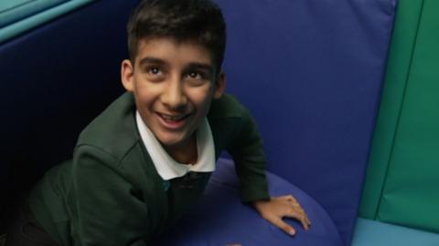 Arav, a year seven school pupil, smiles as he plays in a sensory room