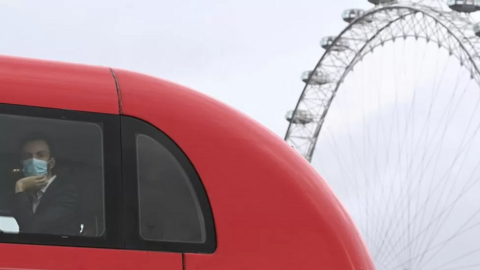 A man in a TfL double-decker bus 