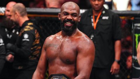 Jon Jones grins in the octagon after a win