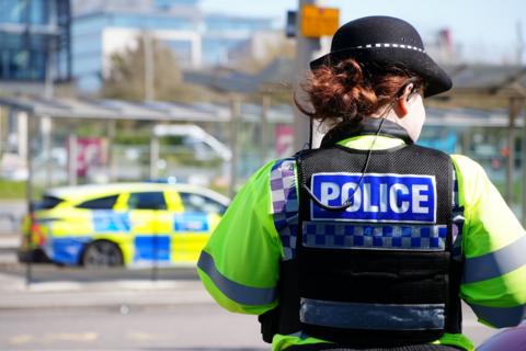 A police officer starts in front of a police car.
