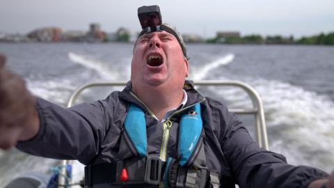 A man is on a high speed boat at Cardiff Bay Barrage. It's at an angle from a GoPro. from a GoPro