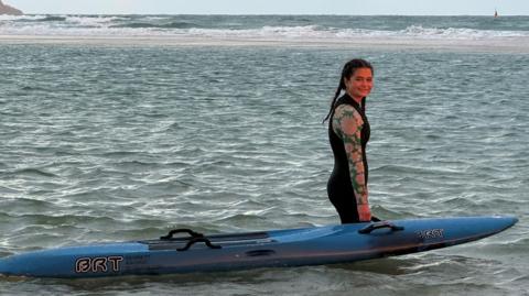 Young girl alongside rescue board in the sea 