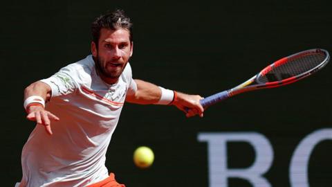 Cameron Norrie, in largely white T-shirt with orange trim, plays a forehand at the Monte Carlo Masters on Sunday