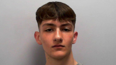 Custody picture of a teenage boy with short brown hair.