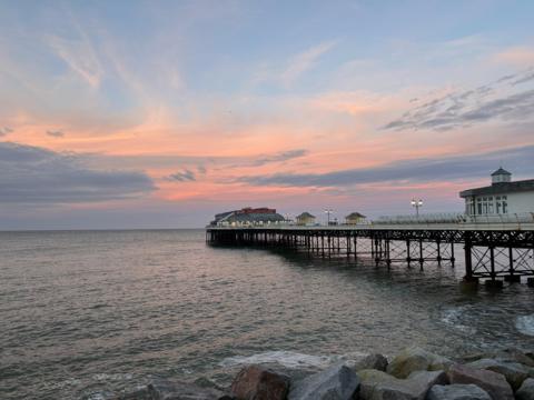 Pink tinge in the sky as the sun sets behind the pier at Cromer, Norfolk 