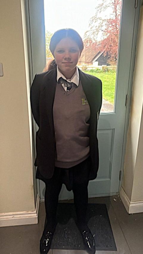 Phoebe, a schoolgirl, wearing a jumper which has been banned by her school