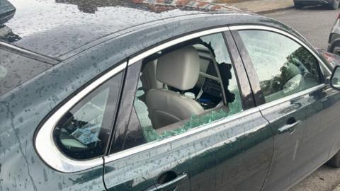 A smashed rear right-hand window on a bottle green car.