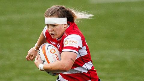 Georgia Brock runs with a rugby ball wrapped under her left arm during a match for Gloucester-Hartpury this season