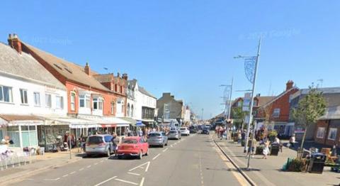 Google view of Mablethorpe High Street looking towards the seafront with cars, shops and people 